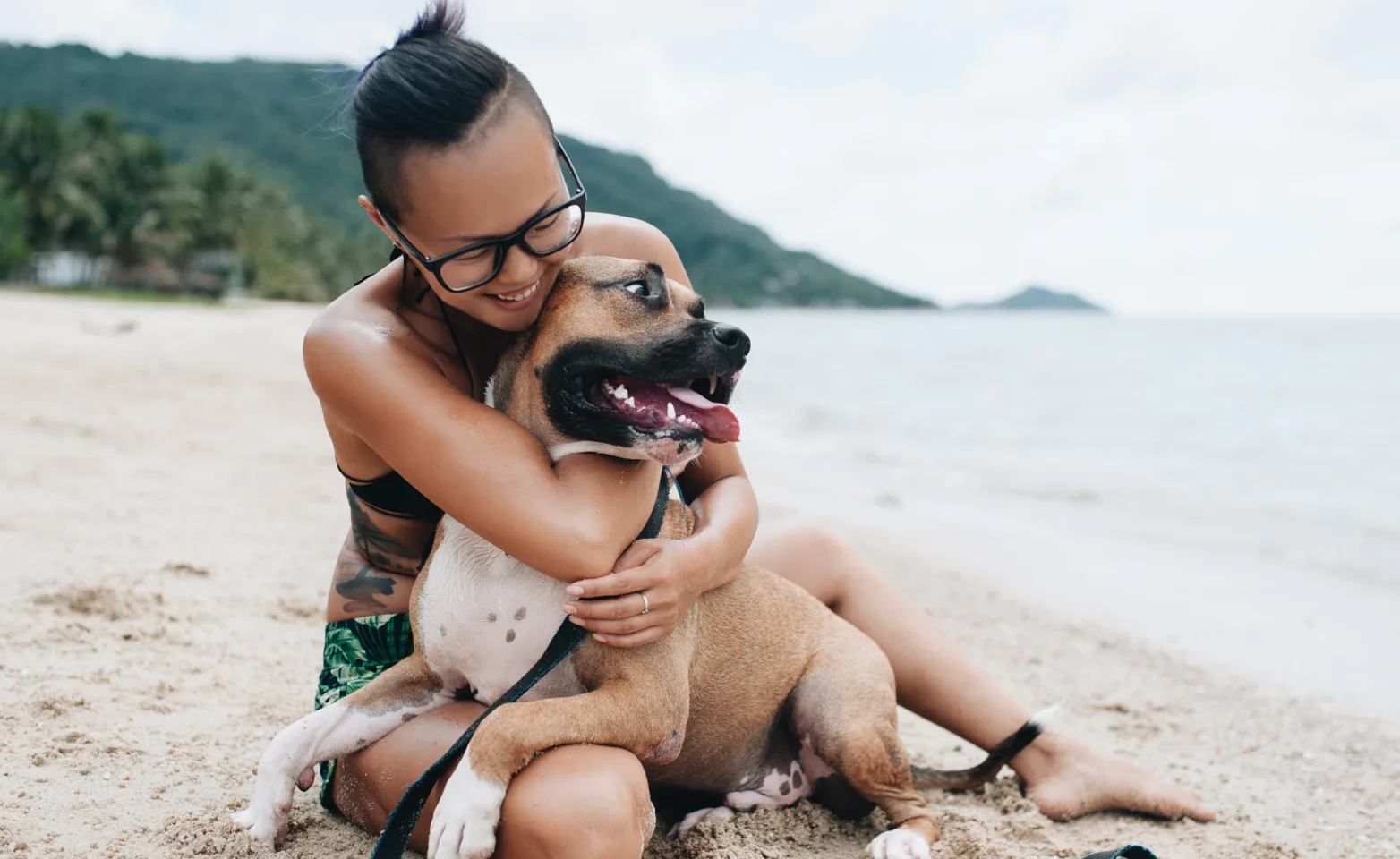 Woman Hugging Dog on Beach
